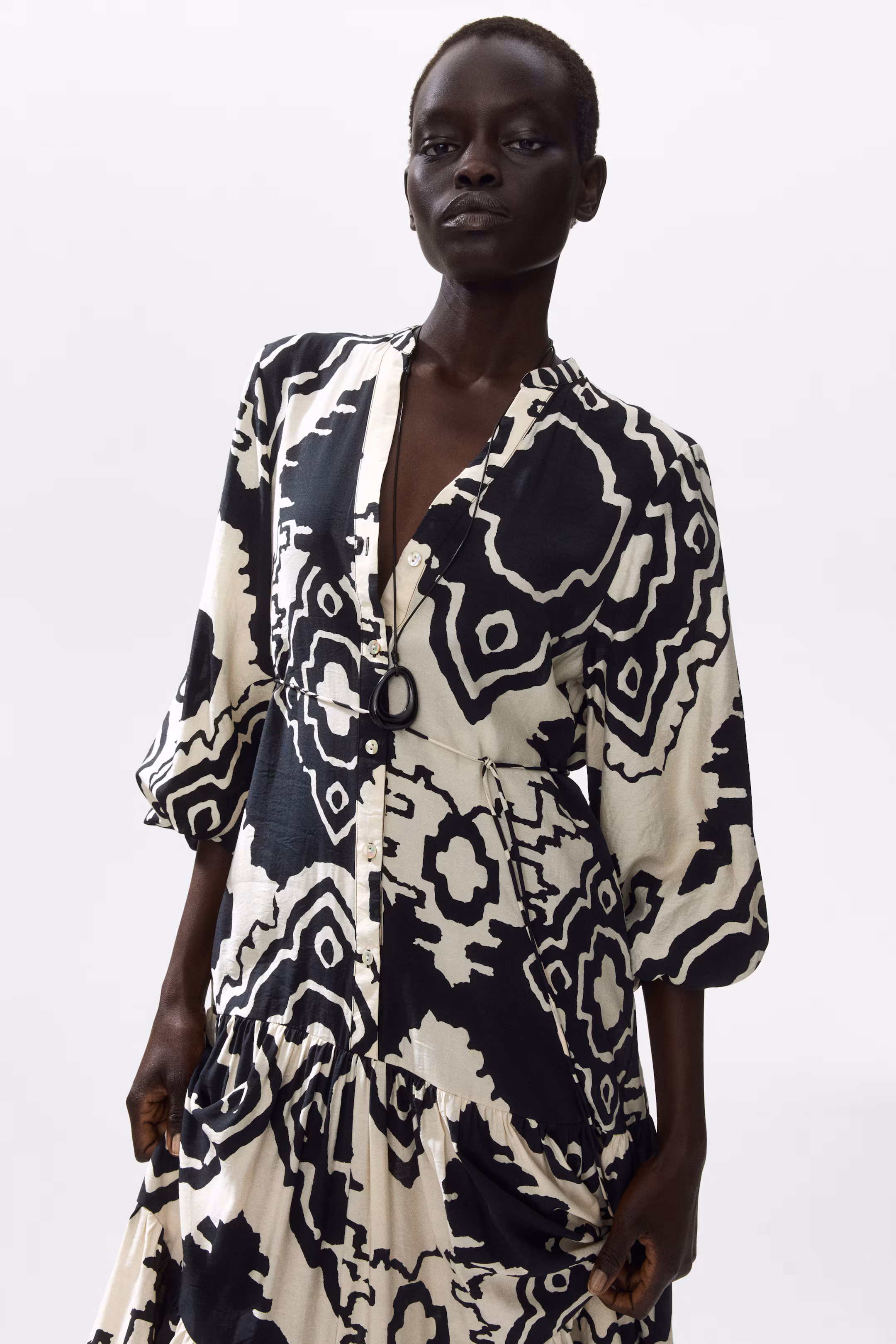 Model in a black-and-cream ikat-print dress